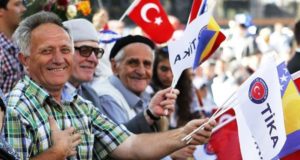 People waving Turkish and Bosnian flags in an opening ceremony of a project by TIKA.